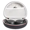 An open black storage case for headphones, with the headphones inside and a charging cable in a mesh pocket. Produktbild-Vorschau