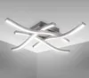 A modern ceiling light fixture with curved LED elements mounted on a square base against a white ceiling. Anteprima dell’immagine prodotto