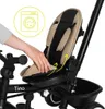 A hand is shown adjusting the seat of a black and beige tricycle, with a washing machine icon in the background. Produktbild-Vorschau