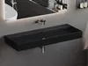 A modern black matte washbasin mounted on a gray wall, with a faucet and drain visible. The reflection in the mirror above shows a white bathtub and toiletries. Produktbild-Vorschau