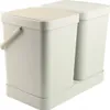 A pair of beige and cream colored trash cans with lids, sitting on a matching base. Produktbild-Vorschau