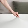 A hand is shown pulling on a white bedsheet. Produktbild-Vorschau