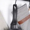 A close-up view of a black frying pan handle hanging on a hook, with two fabric pot holders next to it. Náhled obrázku produktu