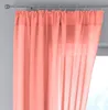 A close-up view of a coral-colored sheer curtain hanging from a curtain rod. Produktbild-Vorschau