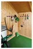 Tools and gardening equipment neatly stored on a rack inside a wooden shed. Anteprima dell’immagine prodotto