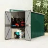 An open garden shed with tools and storage items inside, set against a wall and foliage. Náhled obrázku produktu