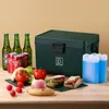 A cooler box with food and drinks arranged around it on a wooden surface. Produktbild-Vorschau