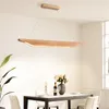 A dining room with a wooden chandelier hanging over a table set for a meal. Voir les images du produit