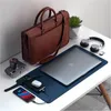 A desk setup with a laptop, power bank, phone, watch, camera, headphones, and a briefcase. Produktbild-Vorschau