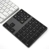 A close-up, diagonal view of two computer keyboards on a white background. One is a silver-colored keyboard, and the other is a dark gray numeric keypad. Produktbild-Vorschau