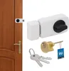 A product shot of a white door lock with keys and a cylinder, next to a section of a wooden door. Náhled obrázku produktu