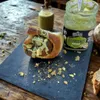 Hefeschnecke mit Pistaziencreme Topping und gehackten Pistazien auf dunkler Steinplatte Produktbild-Vorschau