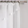 A close-up view of white sheer curtains hanging from a curtain rod. Produktbild-Vorschau