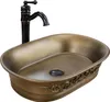 A bronze-colored vessel sink with an ornate design and a black faucet. Náhľad obrázku produktu