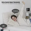 A woman is lying in bed, smiling and reaching her hand up, as if interacting with a smart home device. A smart thermostat is visible on the wall. Produktbild-Vorschau