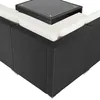 A close-up view of a black rattan outdoor sofa with cream cushions and a glass-top coffee table. Produktbild-Vorschau