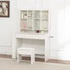 A white vanity table with a mirror and stool, set against a white wall and on a patterned rug. Produktbild-Vorschau