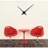 A modern living room setup with a wall clock, two red chairs, and a small red table. Náhled obrázku produktu