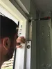 A person is installing a door frame using a level and a screwdriver. Produktbild-Vorschau