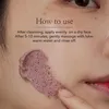 A close-up of a person's face with a pink exfoliating mask being applied. Produktbild-Vorschau