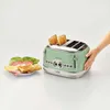 A green vintage toaster with toast popping out, next to a plate of sandwich ingredients. Produktbild-Vorschau