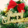 A close-up view of a mini Christmas tree decoration with a red bow and gold lettering that says "Merry Christmas". Náhled obrázku produktu