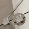 A close-up view of a metal shower support bar hinge mechanism attached to a shower wall. Podgląd zdjęcia produktu