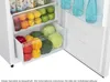 Interior of a refrigerator showing drawers filled with fruits and vegetables, and bottles on a shelf. Produktbild-Vorschau