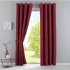 A pair of red curtains is shown, one partially drawn back, revealing a green outdoor scene through a window. Produktbild-Vorschau