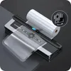 A vacuum sealer machine with a roll of vacuum seal bags on a dark surface. Podgląd zdjęcia produktu