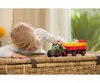 A young girl playing with a toy tractor and trailer with a cow. Produktbild-Vorschau