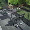A balcony with a table and chairs overlooking a garden. Produktbild-Vorschau