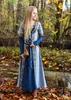 A young girl in a medieval-style dress stands in a forest during autumn. Produktbild-Vorschau