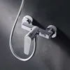 A close-up shot of a chrome shower faucet mounted on a dark gray textured wall. Produktbild-Vorschau