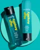 Two bottles of Matrix High Amplify shampoo and conditioner are displayed on a teal background. Produktbild-Vorschau