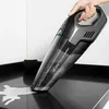 A hand is holding a black and gray handheld vacuum cleaner over a black countertop, cleaning up a spill. Podgląd zdjęcia produktu