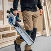 A person is holding a cordless circular saw with a track saw guide. Produktbild-Vorschau