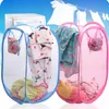 Two pop-up laundry baskets filled with clothes, with a washing machine and clothes on a clothesline in the background. Produktbild-Vorschau