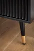 A close-up of the leg of a black nightstand with a gold accent on a wooden floor. Produktbild-Vorschau