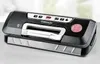A black and silver vacuum sealer machine is shown on a light gray surface. Náhled obrázku produktu