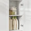 Interior view of a white cabinet with shelves holding various bottles and containers. Náhled obrázku produktu
