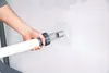 A person's hand is connecting a white hose to a gray fitting on a white surface. Produktbild-Vorschau