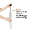 Hands holding a gas lift cylinder, with text instructing to remove a black plastic cap before assembly. Produktbild-Vorschau