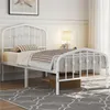 A white metal bed frame with a mattress and bedding in a bedroom setting. Produktbild-Vorschau