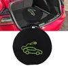 A black circular bag with a green outline of an electric car and charging cable is shown in the foreground, with the open trunk of a red car visible in the background. Podgląd zdjęcia produktu