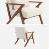 A cream-colored armchair with a wooden frame is shown from two different angles against a white background. Anteprima dell’immagine prodotto