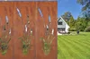 A garden scene with a house and lawn, featuring a decorative metal screen with cattail cutouts in the foreground. Produktbild-Vorschau