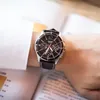 A person wearing a watch on their wrist, with a book in the background. Anteprima dell’immagine prodotto