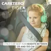A young girl wearing headphones sits in a car seat, secured by a seatbelt. Náhled obrázku produktu