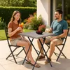 A couple enjoying drinks and snacks at a small square table on a patio. Produktbild-Vorschau
